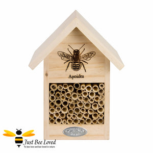 Wooden bee house and hotel featuring wooden tubes and design of a bee on the front.
