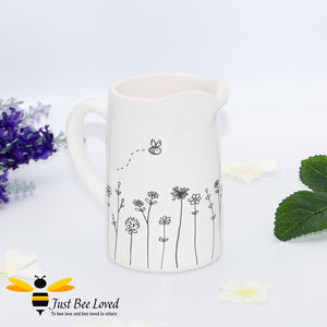 small ivory ceramic milk jug from Bud & Bloom, features a grey line illustration drawing of flowers with flying bees.