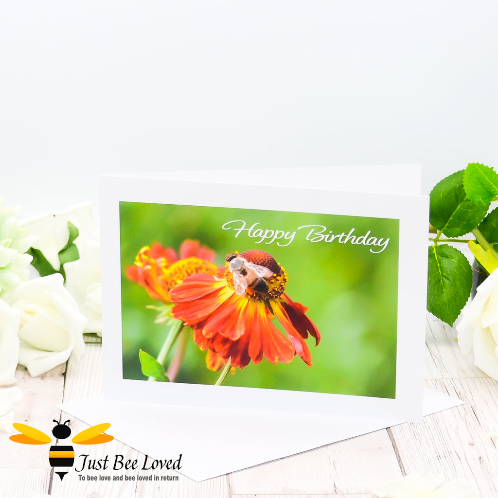 A photographic happy birthday greeting card depicting an image of a honey bee foraging on an orange helenium flower.