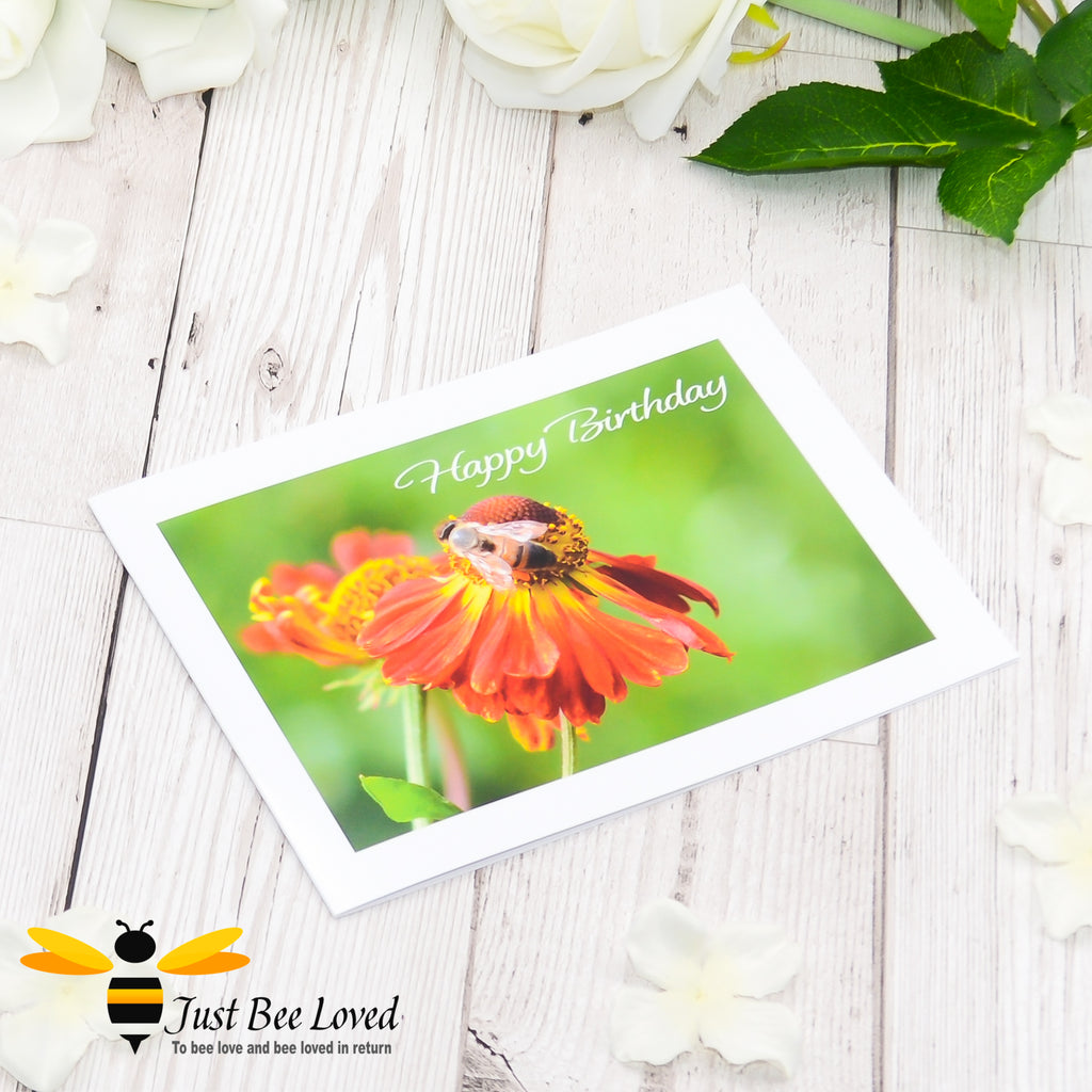 A photographic happy birthday greeting card depicting an image of a honey bee on an orange helenium flower.