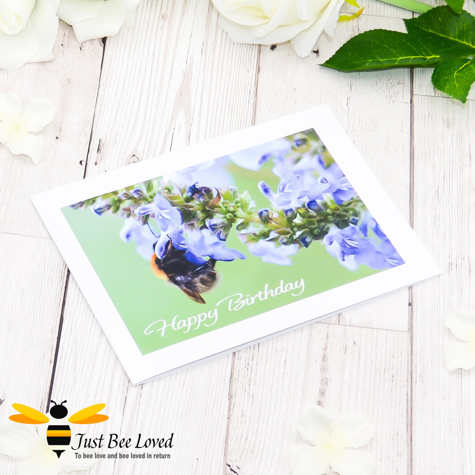 A photographic greeting card featuring an image of a bee drinking nectar from blue salvia flowers with 'Happy Birthday' text.