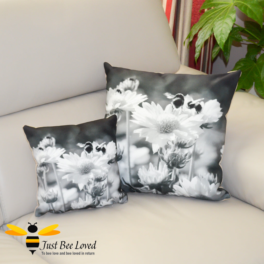 Black and white small and large scatter cushions featuring a photographic image of bumblebees on daisy flowers.