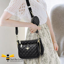 Load image into Gallery viewer, woman wearing black faux leather quilted 3-piece handbag set featuring golden honey bee embellishments