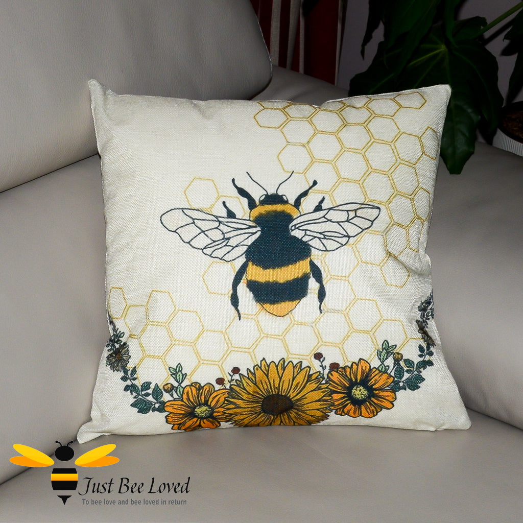 Cream scatter cushion featuring a bumblebee entwinned in hexagonal background with orange sunflowers.