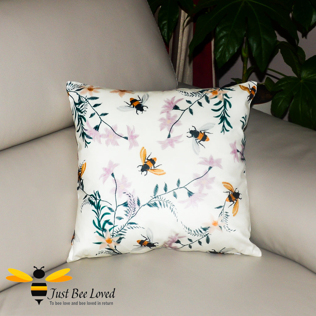 Cream coloured scatter cushion featuring an embroidery design of foraging bees and flowers.