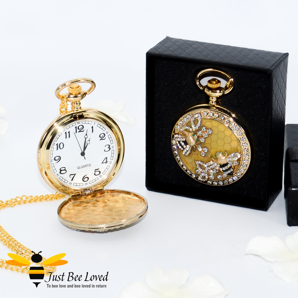 Gold coloured chained pocket watch with white crystal bees on honeycomb background