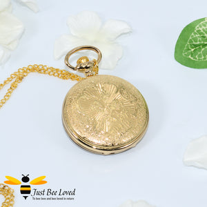 Gold coloured chained pocket watch with white crystal bees on honeycomb background