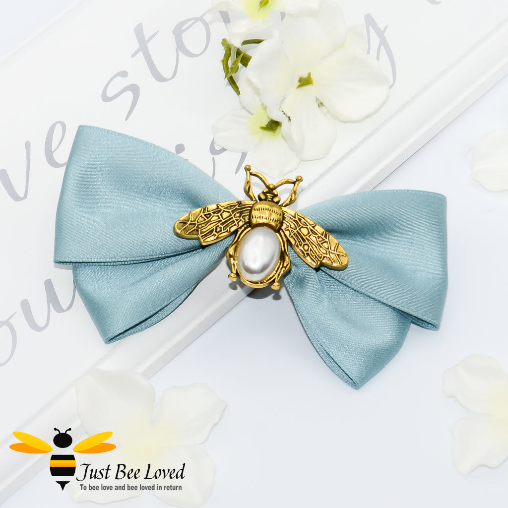 Women's hair bow clip with gold and pearl bee in pastel green.