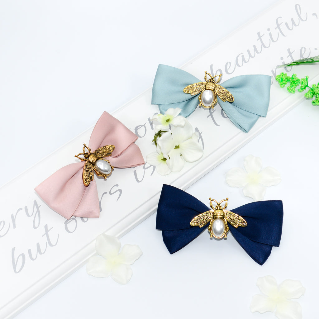 Women's hair bow clip with gold and pearl bees in navy, green and pink