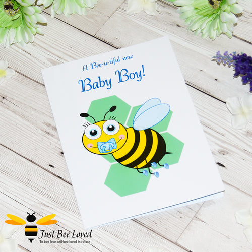 Just Bee Loved Little Bee New Baby Boy Greeting Card featuring a cute baby bumble bee with a dummy design by Artist Yasmin Flemming