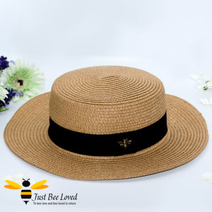 Brown women's straw panama hat with black band and bee embellishment