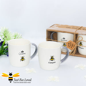 Bee design couple mugs gift set.  Featuring two matching mugs with one saying 'Bee keeper' and the other 'Queen bee'.  In white colour with grey handles. Gift box presented