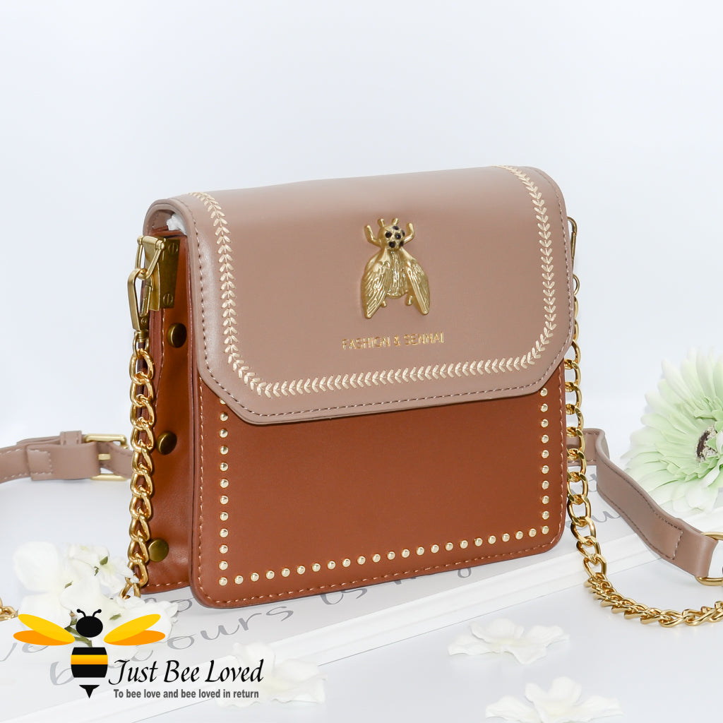 two-tone brown PU with large vintage gold bee embellishment, contrasting cream stitching, gold side studs with matching strap of part leather and gold chain.