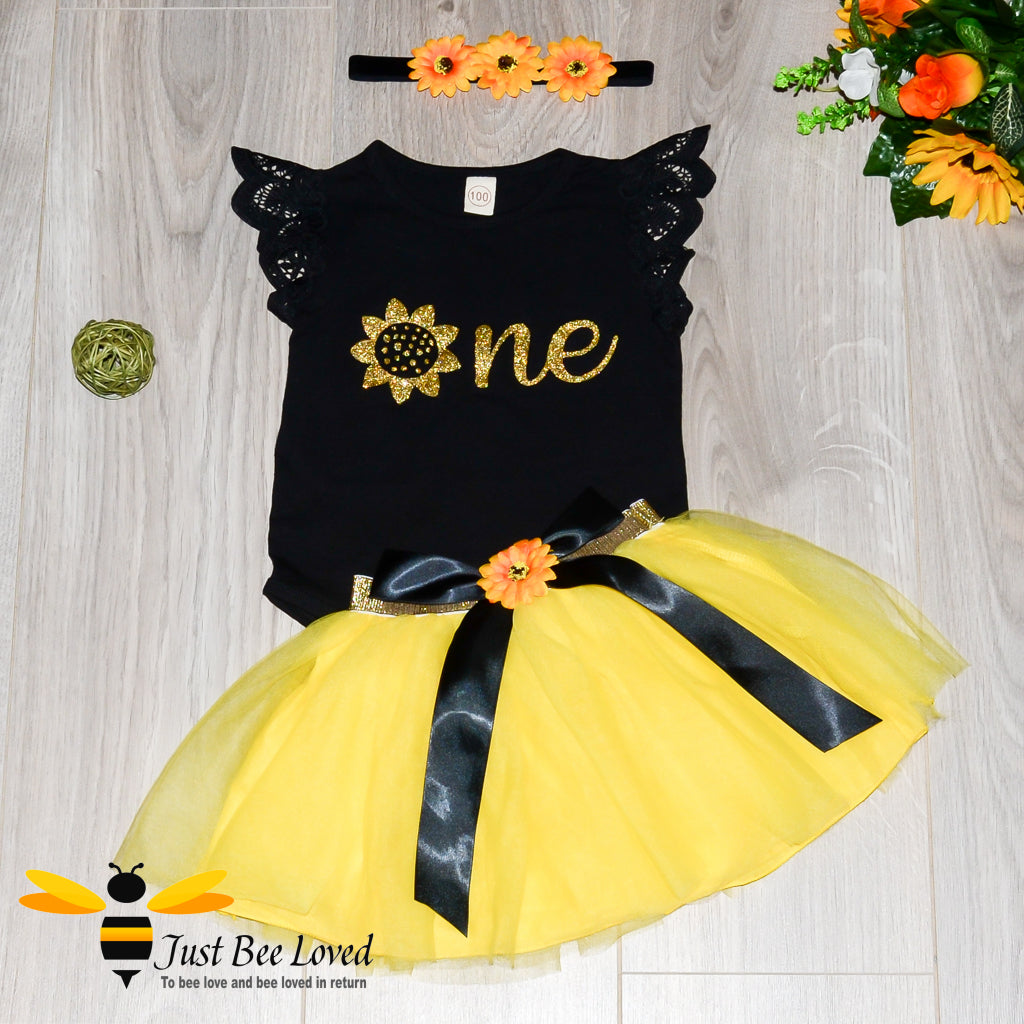 baby girl bee inspired tutu 3-piece party dress. Featuring a black lattice short sleeved romper with a golden sunflower, fully lined yellow tutu skirt and matching sunflower headband.