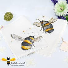 Load image into Gallery viewer, luxurious cream coloured cotton tea-towel featuring bumblebees in flight art work by British artist Joanna Williams.