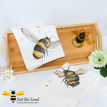 Load image into Gallery viewer, bamboo serving tray hand-painted by British artist Joanna Williams; featuring a painting of a bumblebee, with matching bee print cream cotton tea towel