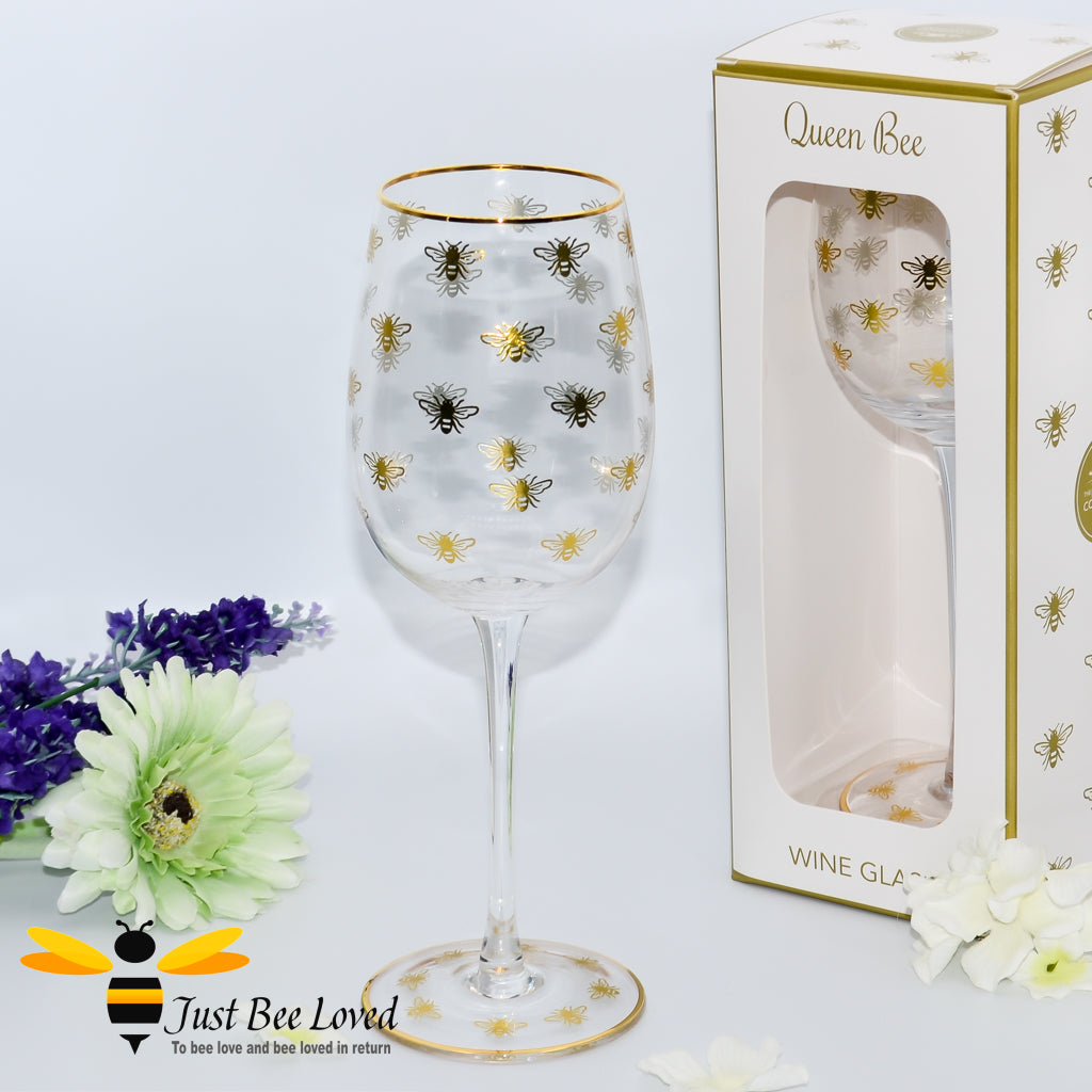 tall stemmed wine glass decorated with golden bees and gold rim
