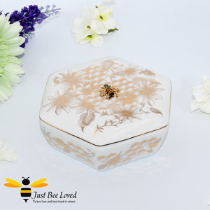 Fine china accessory trinket box decorated with golden honeycomb, bees and flowers, with a rhinestone bee embellishment.