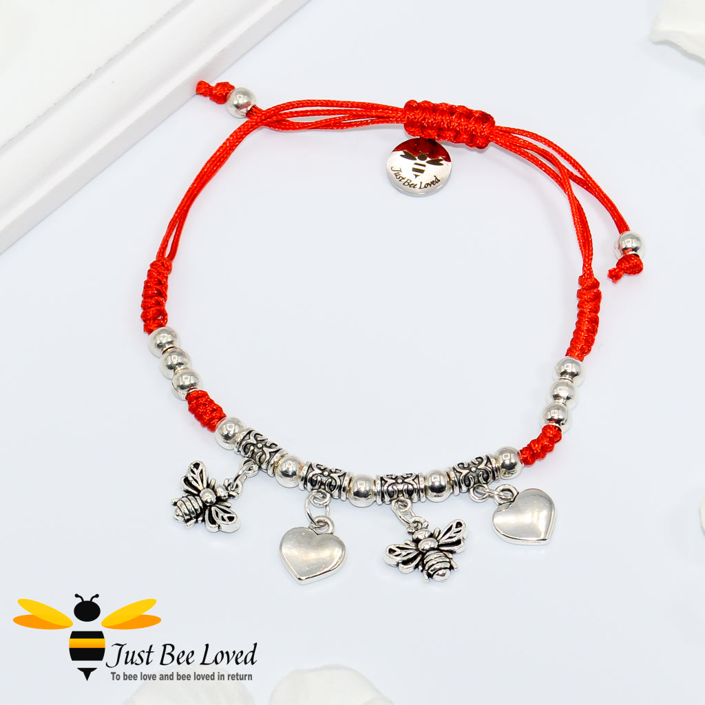 Handmade bohemian gypsy styled red rope bracelet featuring two silver colour bees and two love-heart pendants with beads.