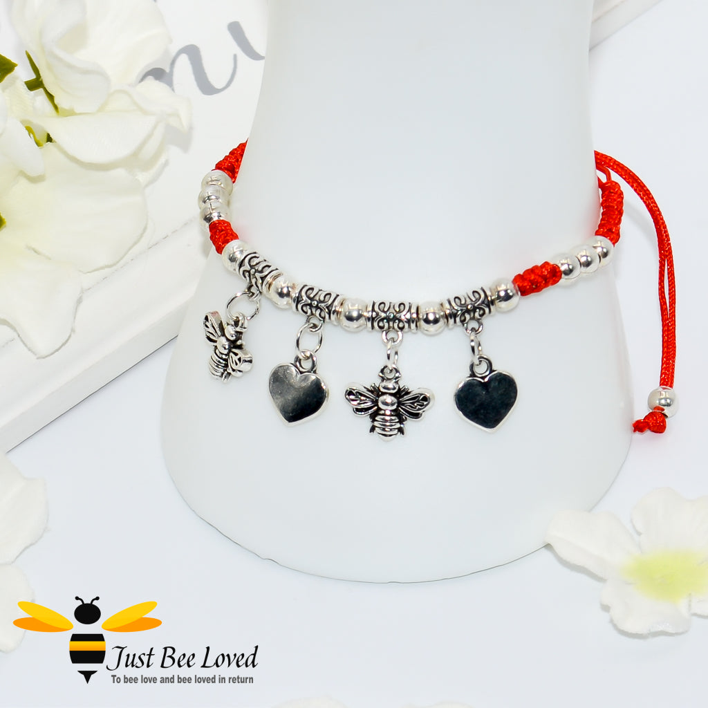 Handmade bohemian gypsy styled red rope bracelet featuring two silver bees and two heart pendants with beads.