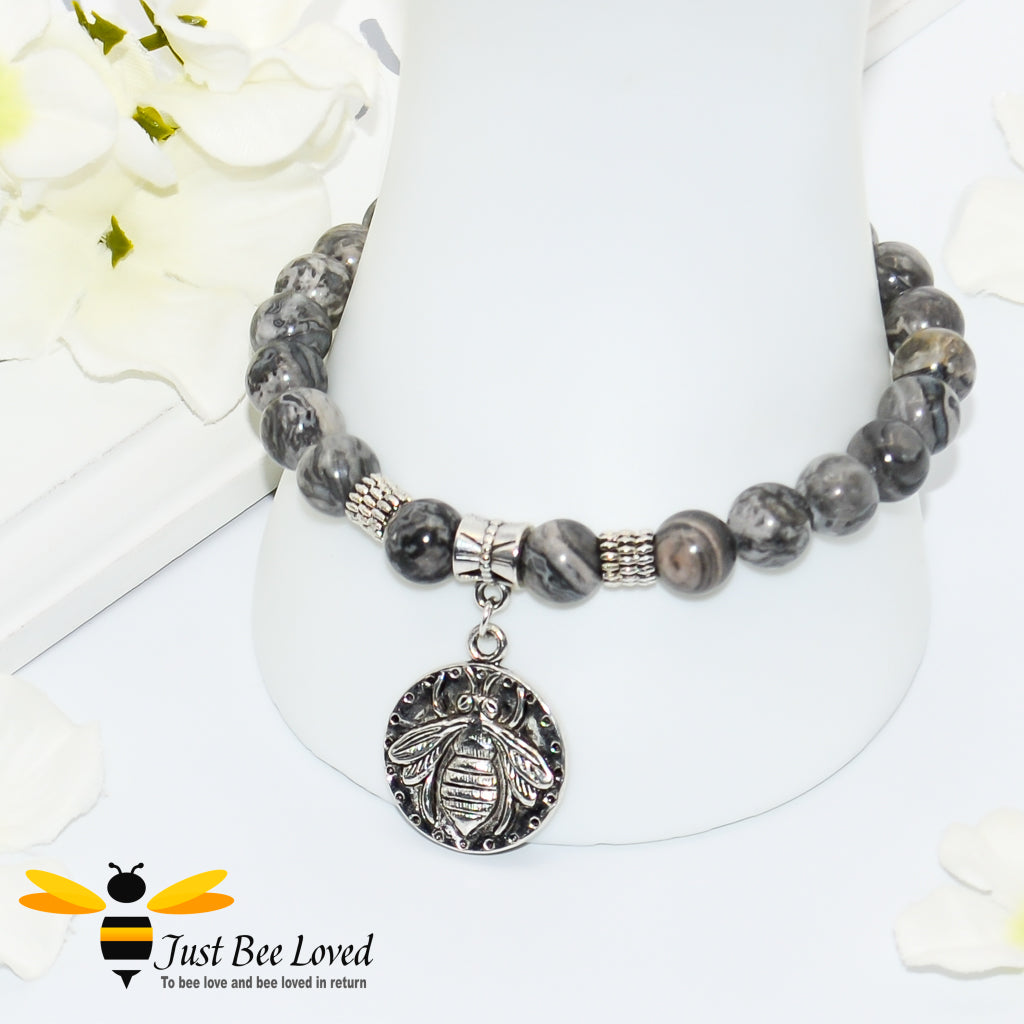 Handmade mottled grey natural stone bead bracelet featuring silver bee charm. 