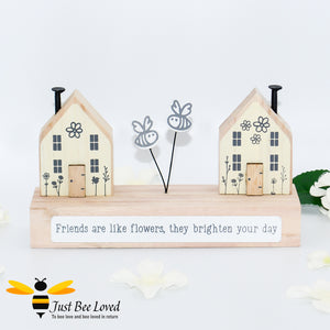 wooden freestanding plaque featuring two houses and bumblebees with "Friends are like flowers, they brighten your day" message.