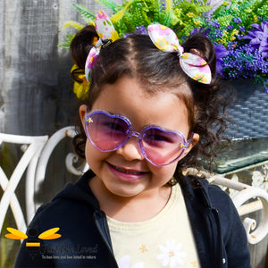 Little girl wearing purple heart shaped bee sunglasses
