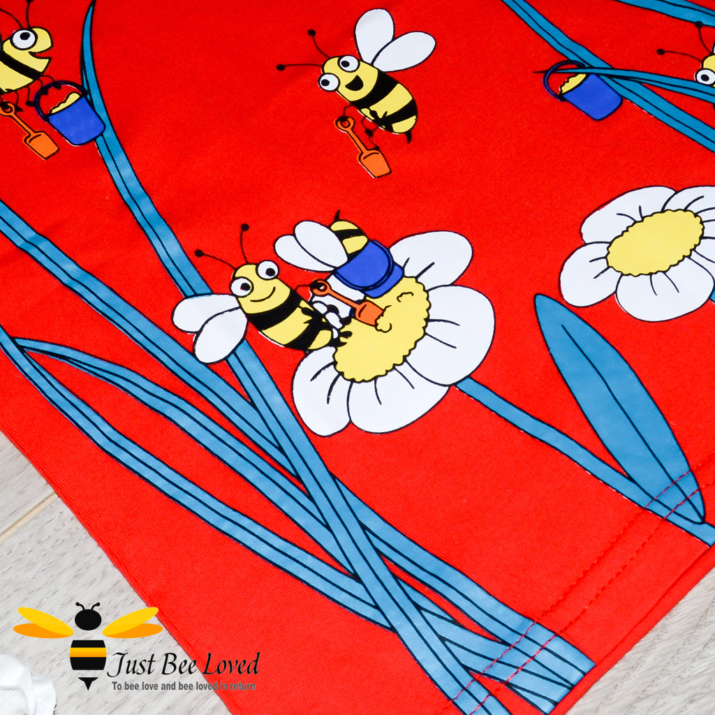 red T-shirt featuring a vibrant print of cartoon honey bees collecting buzzing around carrying their honey-pots