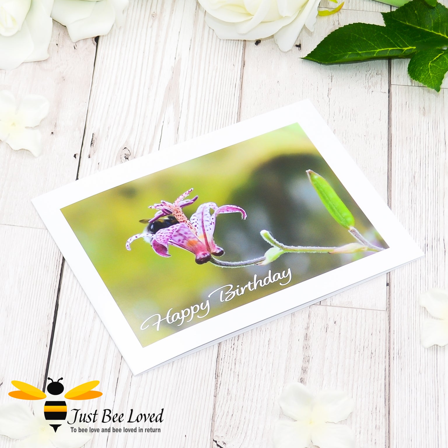A happy birthday greeting bee card featuring an image of a bumblebee deep inside a flower cup.