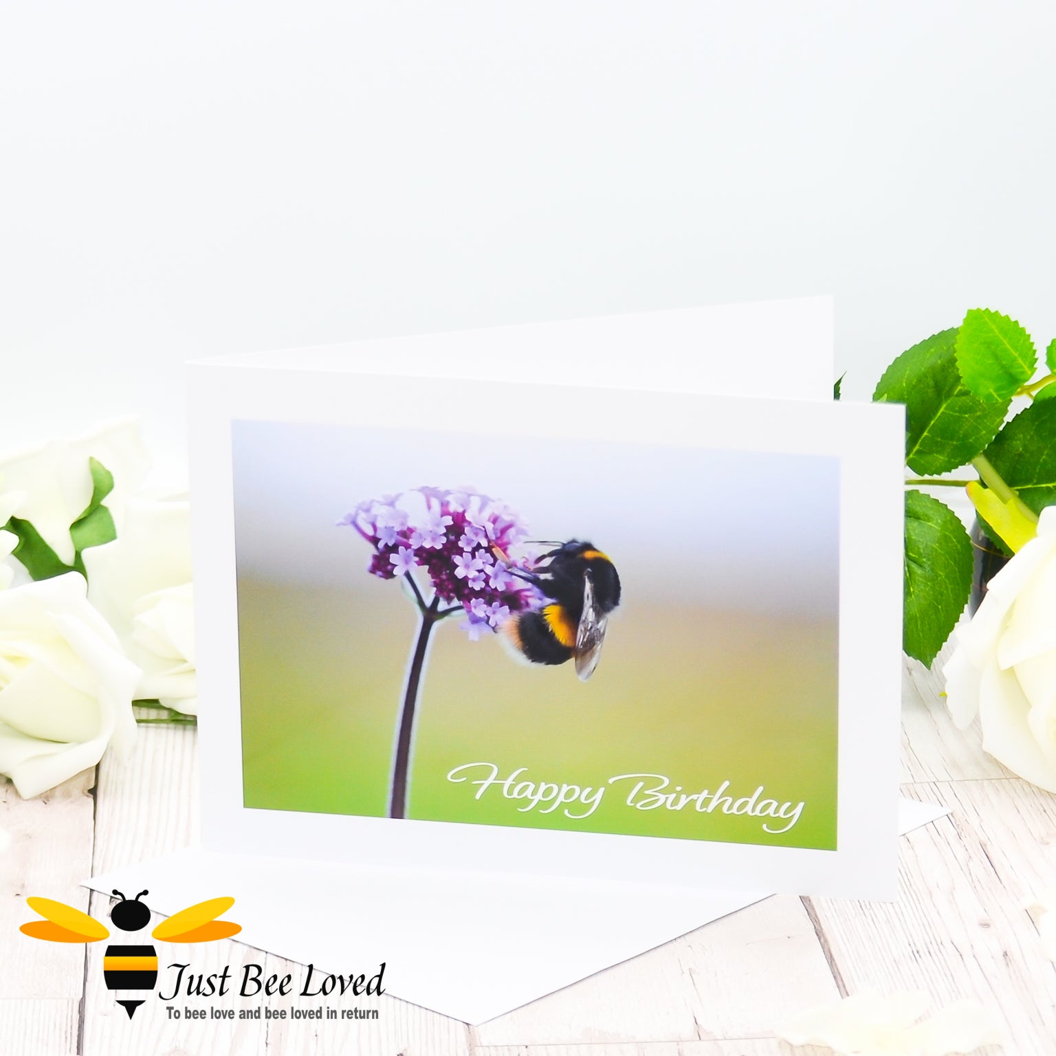 A greeting card of an original photographic print of a bumblebee on a purple Verbena flower with the text 'Happy Birthday'.