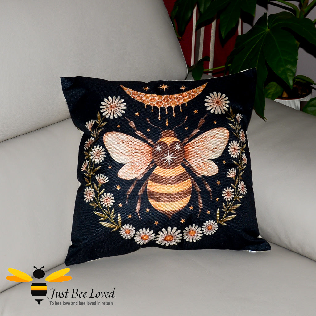 Black cushion featuring a honey dripping crescent moon, bee and daisy flowers.