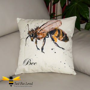 Scatter cushion featuring a watercolour image of a honey bee on a splashed colour background with "Bee" calligraphy writing.