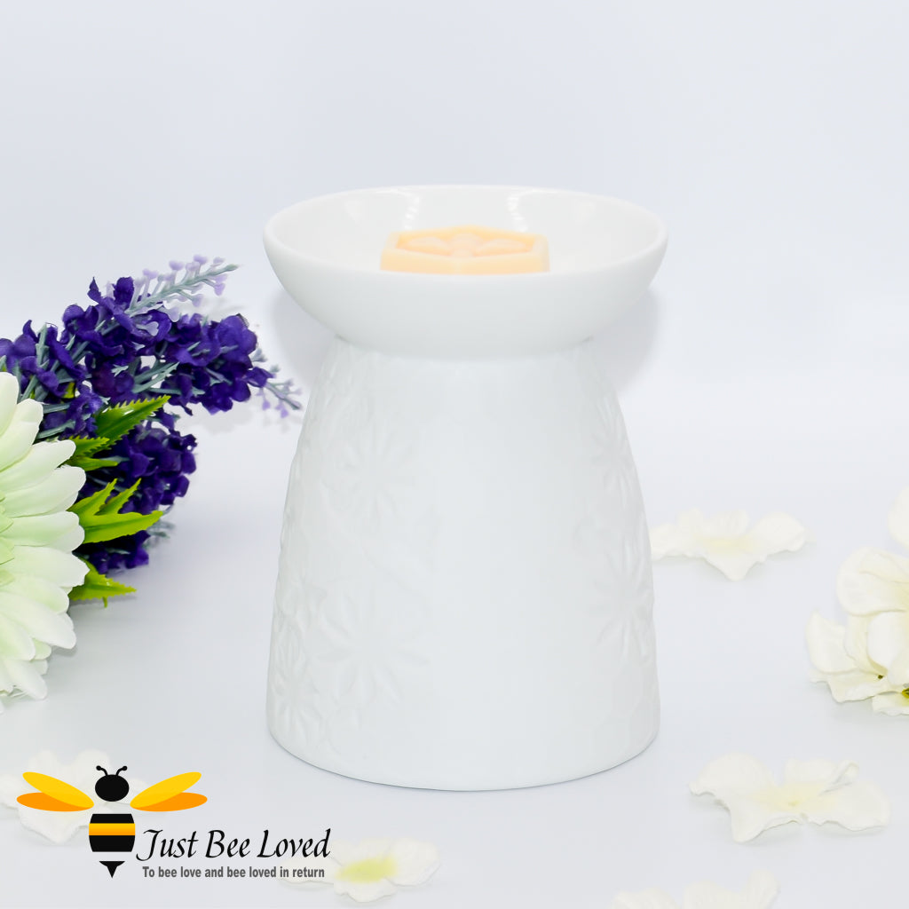 white ceramic burner featuring an etched design of honeycomb, flowers and bees.  
