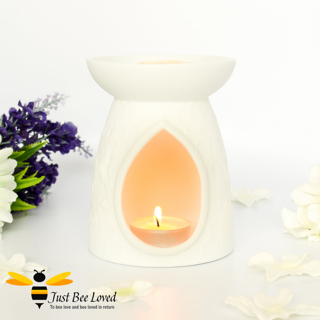 white ceramic burner featuring an etched design of honeycomb, flowers and bees.  