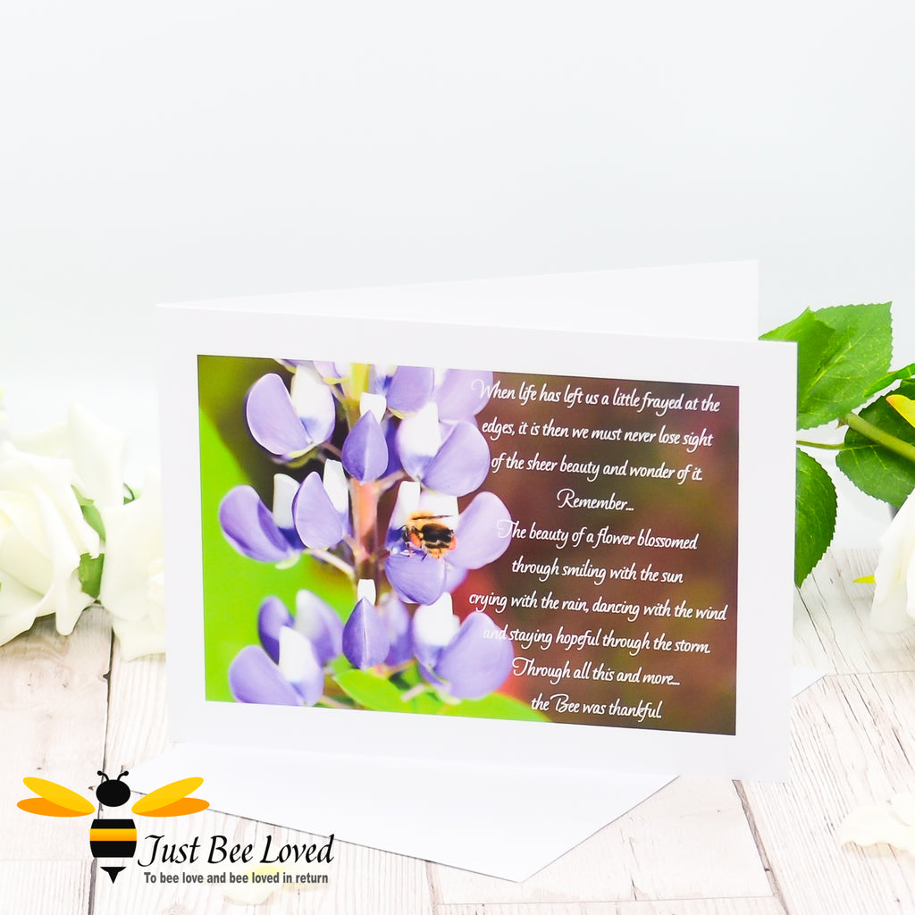 a greeting card showing a landscape photographic print of a wild bee foraging on purple lupine flowers with an accompanying inspirational verse.