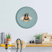 Load image into Gallery viewer, Teal blue round wall clock with bumblebee illustration by Meg Hawkins