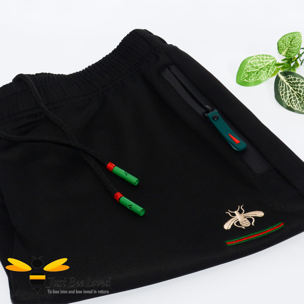 2-piece black t-shirt and shorts embroidered with a gold bee and colour coordinating red & green stripes.
