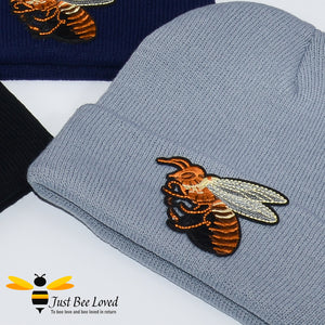Grey ribbed knit beanie skull caps featuring a large front embroidered bee motif.