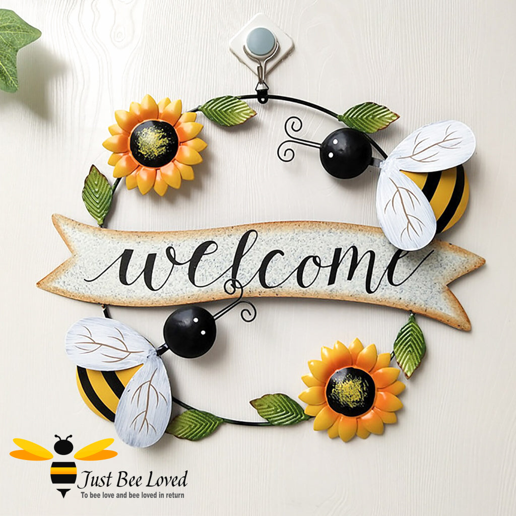 circular metal welcome sign featuring colourful painted bumblebees, sunflowers and leaves.