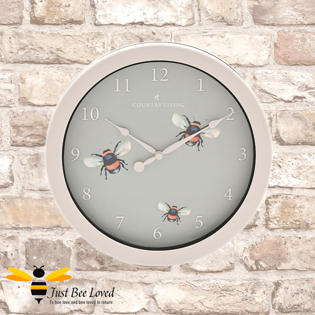 Outdoor and indoor wall clock in beige and teal colour with bumblebees clock face design. 