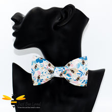 Load image into Gallery viewer, pre-tied white bow tie featuring an all over colourful print of bumblebees amongst a blue floral splash background