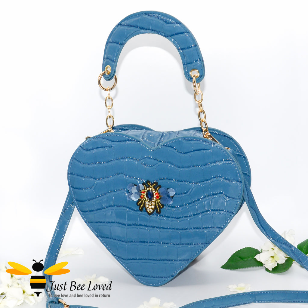 Blue faux patent leather heart-shaped handbag featuring embossed crocodile skin, with bee embellishment 