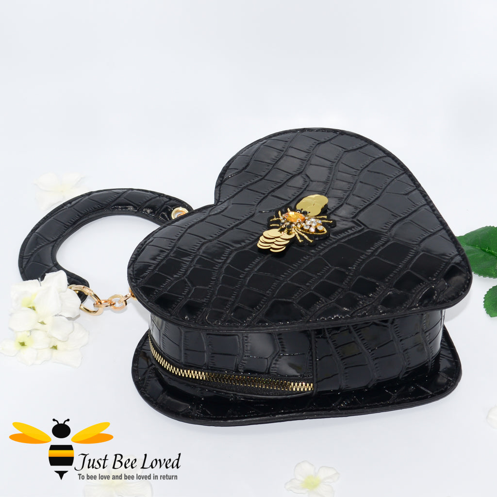 Black faux patent leather heart-shaped handbag featuring embossed crocodile skin, with bee embellishment 