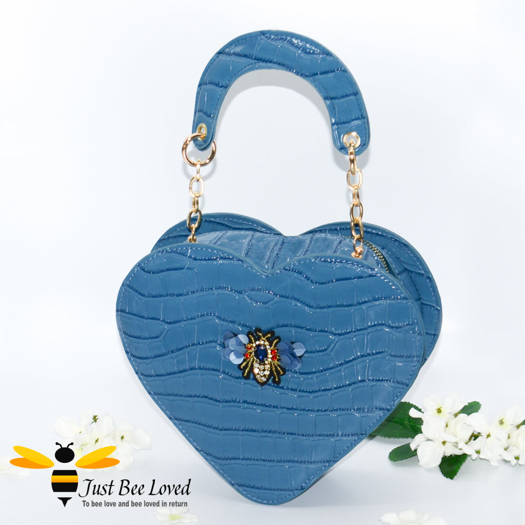 Blue faux patent leather heart-shaped handbag featuring embossed crocodile skin, with bee embellishment 
