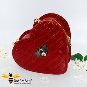 Red faux patent leather heart-shaped handbag featuring embossed crocodile skin, detailed with a handmade crystal bee at its centre 