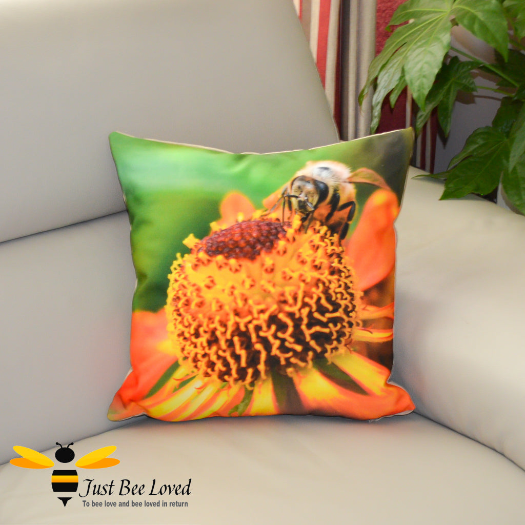 A photographic cushion featuring an image of a bee foraging on a helenium flower, with a vibrant green background. 