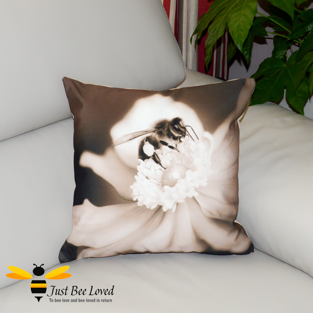 A photographic scatter cushion featuring a sepia-toned image of a honey bee foraging on a white flower.