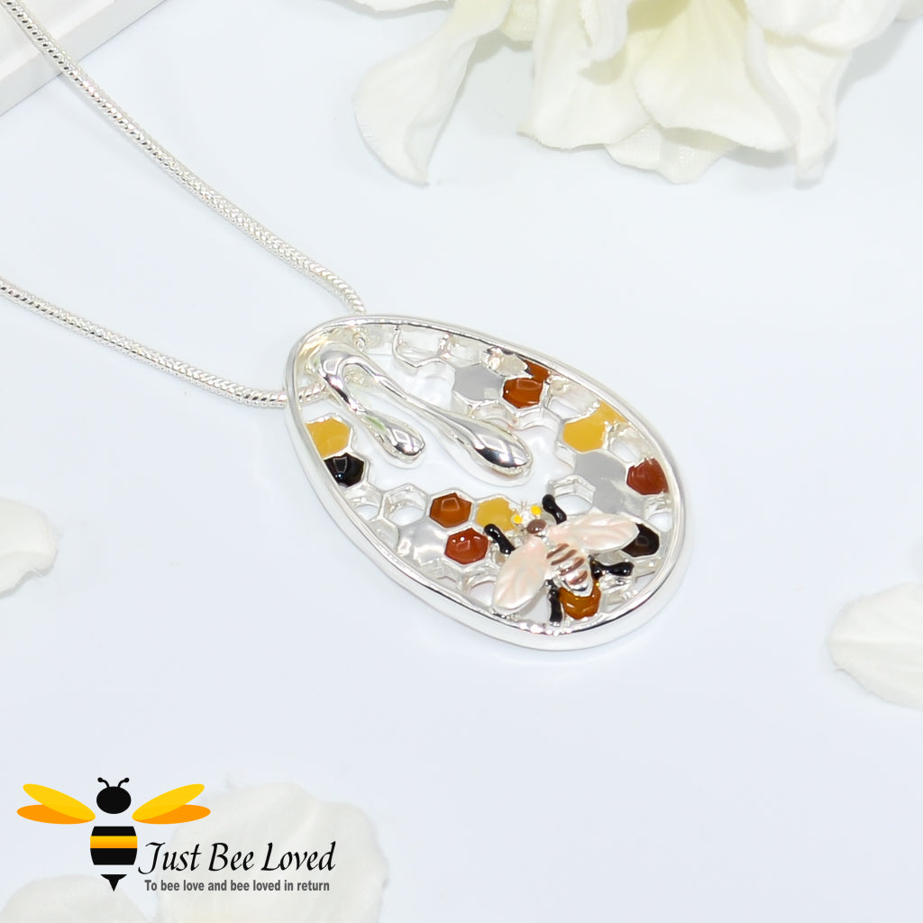 Metallic silver pendant necklace designed to resemble honey drips and pollen with a honey bee motif