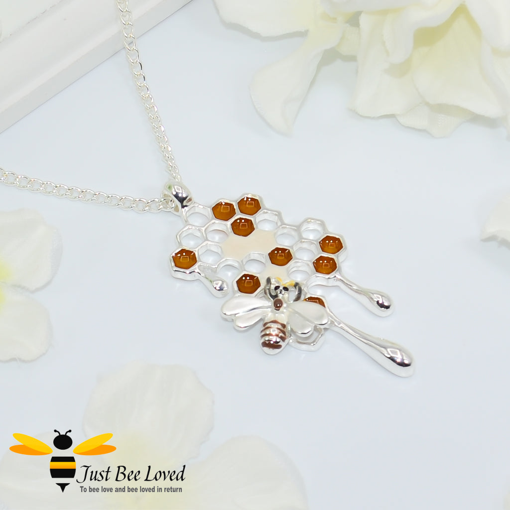 Metallic silver pendant necklace designed to resemble honey drips and pollen with a honey bee motif