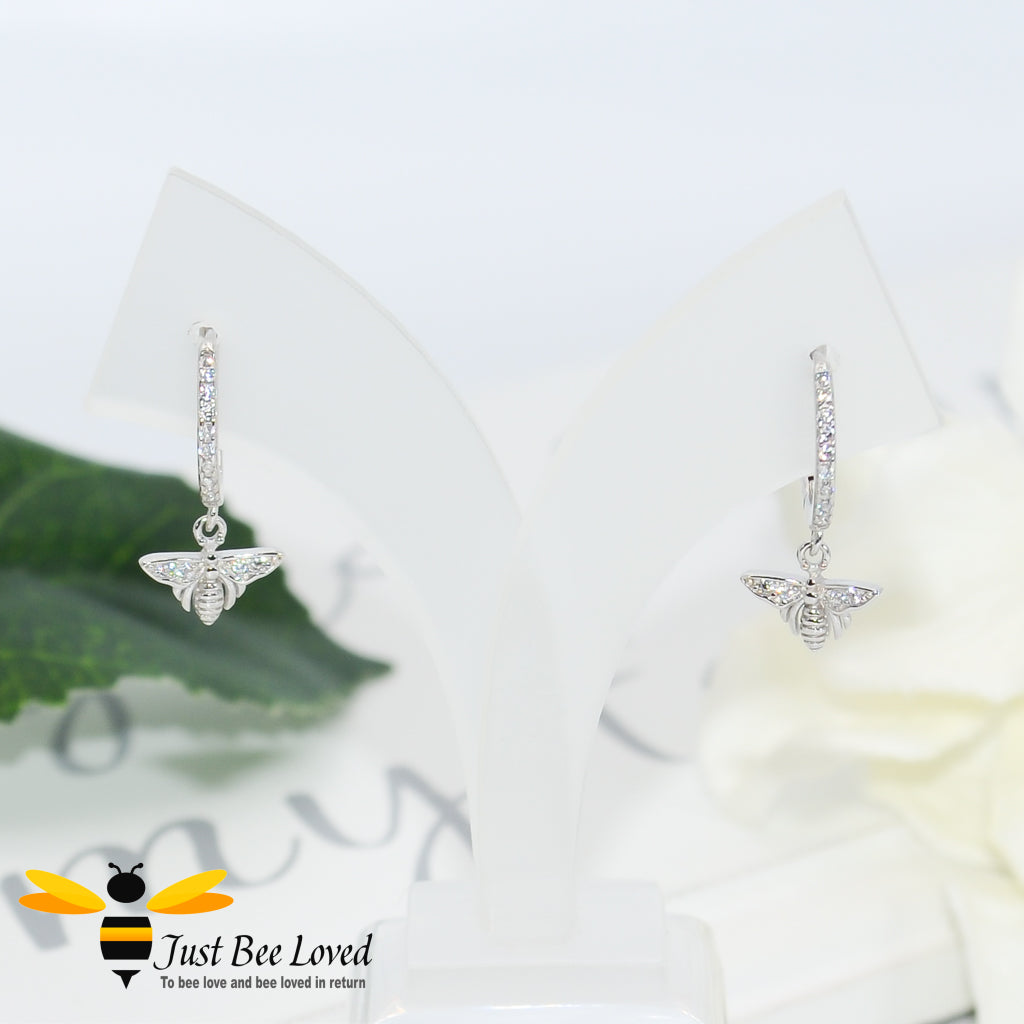 sterling silver hoop earrings inlaid with white cubic zirconia crystals with a little bee pendant